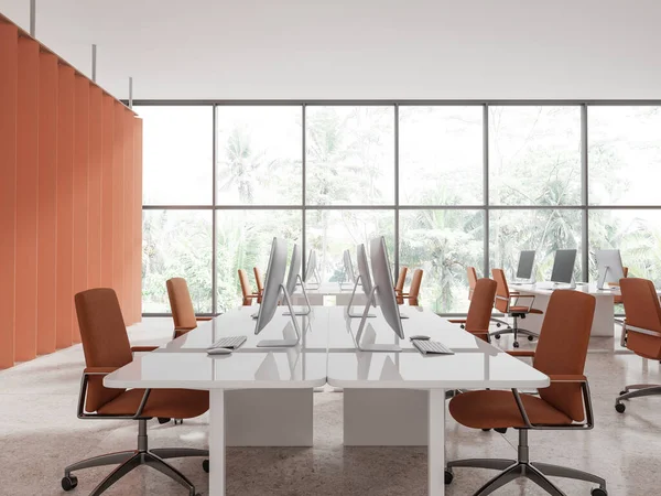 Interior of modern office with orange walls, tiled floor, white computer tables with orange chairs standing near panoramic window with tropical view. 3d rendering