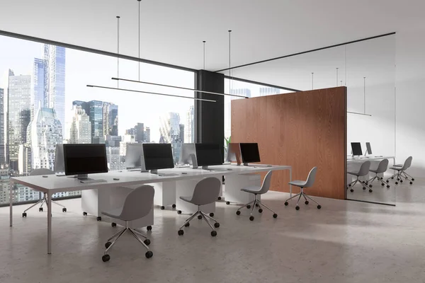 stock image Corner view of coworking interior with chairs and pc desktop, wooden partition on concrete floor. Office work zone with panoramic window on New York skyscrapers. 3D rendering