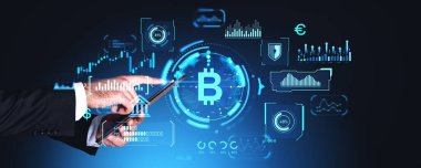 Tablet kullanan, parmak dokundurmalı eller. Grafik çizelgesi ve dijital göstergeleri olan parlayan bitcoin simgesi. Kripto para birimi, mali istatistik ve çevrimiçi ticaret kavramı