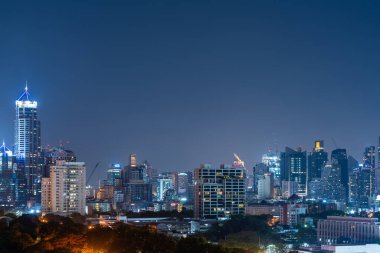 Bangkok şehir manzarası geceleri panoramik manzara, yeşil ışıklı halk parkı. Asya iş şehri silueti ve boş fotokopi alanı. Tayland sermayesi ve şirket binaları