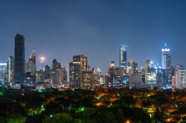 Parlayan gökdelenleri, pencereleri ve ağaçları olan Bangkok şehri manzarası. Tayland 'da turizm ve seyahat kavramı