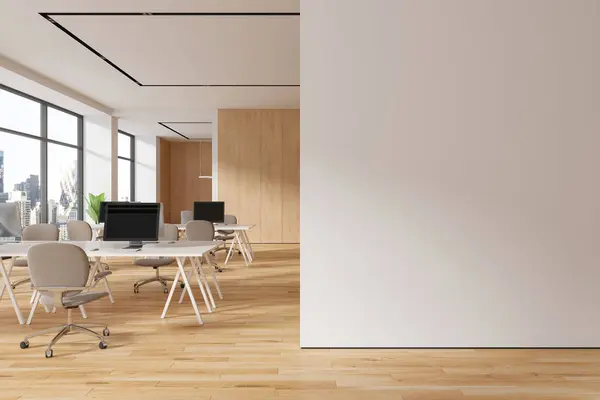 Stylish office interior with pc monitors, coworking room with armchairs and shared desk on hardwood floor. Panoramic window on New York skyscrapers. 3D rendering
