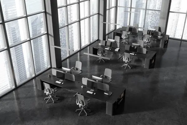Top view of dark office interior with pc computers on desk in row, grey granite floor. Stylish open space coworking loft with panoramic window on Singapore skyscrapers. 3D rendering
