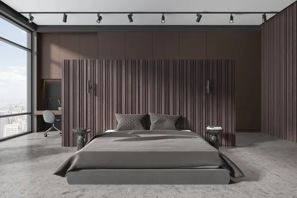 Interior of stylish bedroom with wooden and brown walls, concrete floor, comfortable king size bed with brown blanket and small table with gray chair. 3d rendering