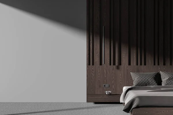 Dark home bedroom interior with bed and nightstand, grey carpet on the floor. Relax or sleep space with decoration and brown wooden paneling, mock up empty copy space wall. 3D rendering