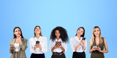 Akıllı telefon ya da tabletle çok uluslu iş kadınları portreleri, yukarı bakıp hayal kuran sıralanmış genç kadınlar. Plan kavramı, çevrimiçi ağ, iletişim ve takım çalışması
