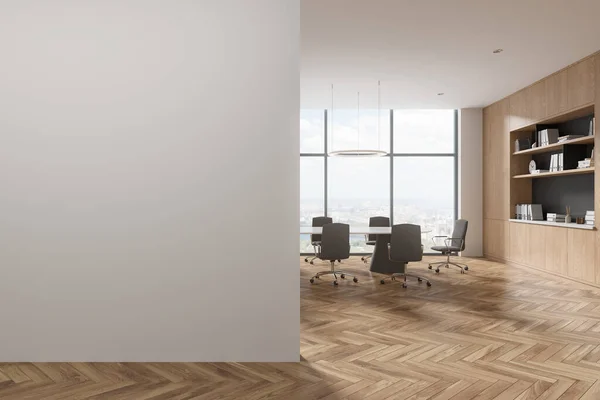 Interior of modern meeting room with white walls, wooden floor, long conference table with gray chairs, wooden bookcase and copy space wall on the left. 3d rendering