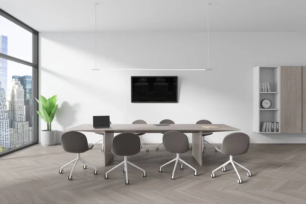 Interior of modern office meeting room with white walls, concrete floor, long conference table with gray chairs and flat screen TV on the wall. 3d rendering