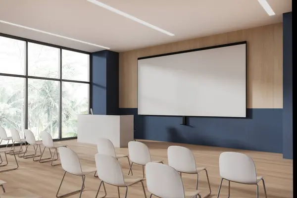 Corner of modern lecture hall or college classroom with blue and wooden walls, wooden floor, rows of white chairs, white speaker desk with computer and mock up projection screen. 3d rendering