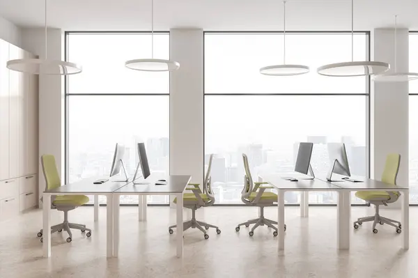 Cozy coworking interior with pc monitors on desk in row, shelf on light concrete floor. White workplace with technology and panoramic window on Paris skyscrapers. 3D rendering