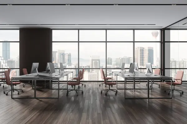 Modern office interior with pc computers on shared desk in row, hardwood floor. Corporate workspace with minimalist furniture and technology, panoramic window on skyscrapers. 3D rendering