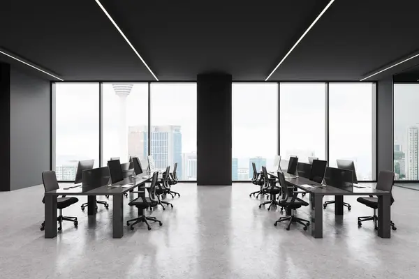 Modern dark open space office interior with pc computers and desk in row, light concrete floor. Stylish coworking room with panoramic window on Kuala Lumpur. 3D rendering