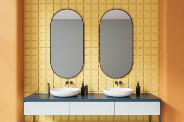 Çift lavabolu ve oval aynalı parlak fayanslı banyo, aksesuarlı minimalist gösteriş. Lüks dairede sarı kiremit duvarlı banyo alanı. 3B görüntüleme