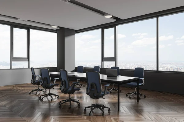Dark conference interior with chairs and board, side view furniture with laptop on hardwood floor. Minimalist meeting corner and panoramic window on New York city view. 3D rendering
