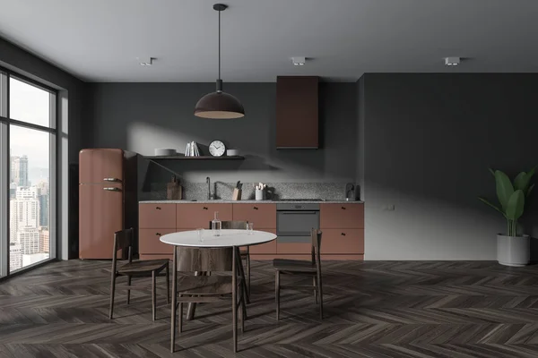Dark home kitchen interior with dinner table and chairs, fridge and cabinet with kitchenware. Brown eating and cooking area, panoramic window on skyscrapers. 3D rendering