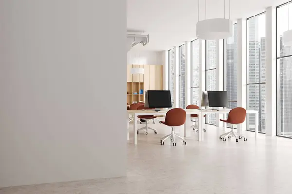 Corner of stylish open space office with white walls, concrete floor, row of computer desks with red chairs, wooden bookcase with folders and copy space wall on the left. 3d rendering