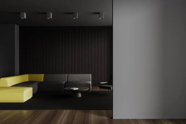 Dark home living room interior with sofa, armchair and coffee table with a book and carpet on hardwood floor. Yellow and grey chill zone with mock up copy space blank wall. 3D rendering
