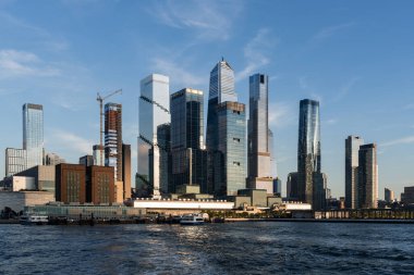 New York batı yakası ve Hudson Yards inşaatı, rıhtım ve ofis gökdelenleri ile gün ışığında. Manhattan ufuk çizgisi, şehir merkezi ve finans sektörü