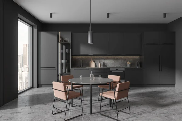 Dark home kitchen interior with dinner table and armchairs, cooking zone with cabinet and refrigerator. Panoramic window on Kuala Lumpur skyscrapers. 3D rendering
