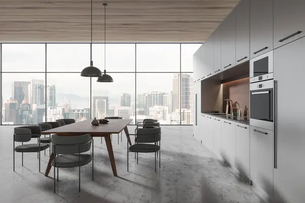 Dark home kitchen interior with dining table and chairs, cooking cabinet with oven and kitchenware, eating table and panoramic window on Kuala Lumpur skyscrapers. 3D rendering