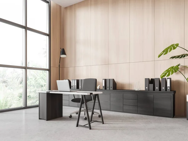 Corner of stylish panoramic CEO office with wooden walls, concrete floor, dark wooden computer table with gray chair and big window with tropical view. 3d rendering