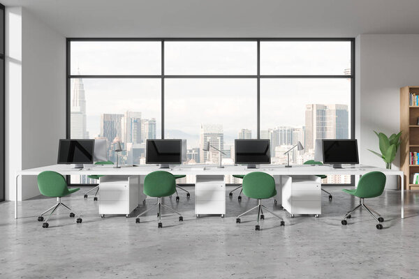 Интерьер современного открытого пространства с белыми стенами, бетонный пол, ряд компьютерных столов с зелеными стульями и панорамное окно с городским пейзажем. 3d-рендеринг