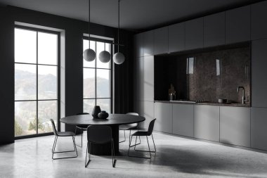 Gri duvarlı şık bir mutfak, beton zemin, rahat gri dolaplar ve ocakta yapılmış dolaplar ve lavabo ve siyah sandalyeli yuvarlak yemek masası. 3d oluşturma