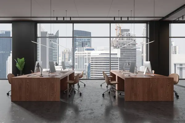 Gri duvarları, beton zemini, sandalyeli ve pencereli sıralı devasa bilgisayar masaları olan şık bir açık uzay ofisi. 3d oluşturma