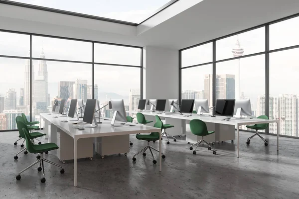 Cozy workspace interior with pc computers and chairs, side view shared table on concrete floor. Coworking corner near panoramic window on Kuala Lumpur skyscrapers. 3D rendering
