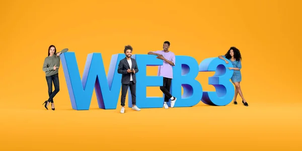 Happy multinational young people with phone, finger point to web3 letters on orange background. Next generation of world wide web. Concept of decentralization and innovation