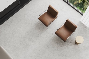 En şık ev manzarası rahatlama yeri iki kahverengi deri koltuk, şömine ve açık beton zemin. Tropik bölgelerde panoramik pencere. 3B görüntüleme