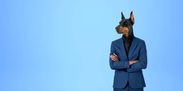 Portrait of confident businessman with dog head standing with crossed arms over blue copy space background. Concept of leadership
