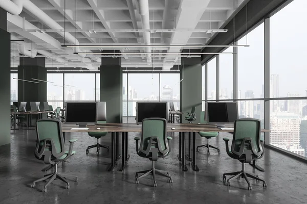 Modern office workplace interior with green armchairs and desk in row, grey concrete floor. Cozy coworking loft with columns and panoramic window on Singapore skyscrapers. 3D rendering