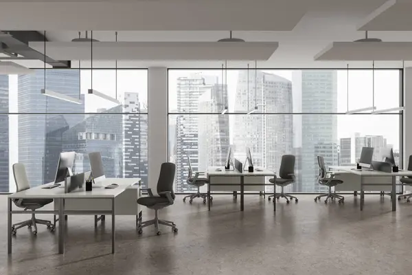 Stylish coworking interior with pc desktop on work table in row, light concrete floor. Minimalist workplace with panoramic window on Singapore skyscrapers. 3D rendering