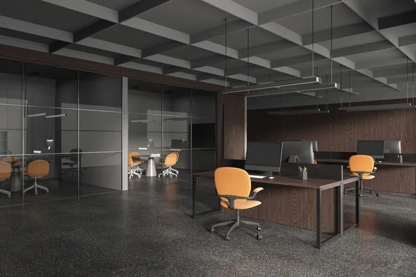 Corner of stylish open space office with wooden and gray walls, concrete floor, row of computer desks with orange chairs and meeting room next to it. 3d rendering
