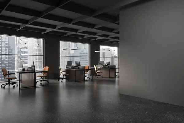 Corner of stylish open space office with gray walls, concrete floor, row of computer tables with chairs and copy space wall on the right. 3d rendering