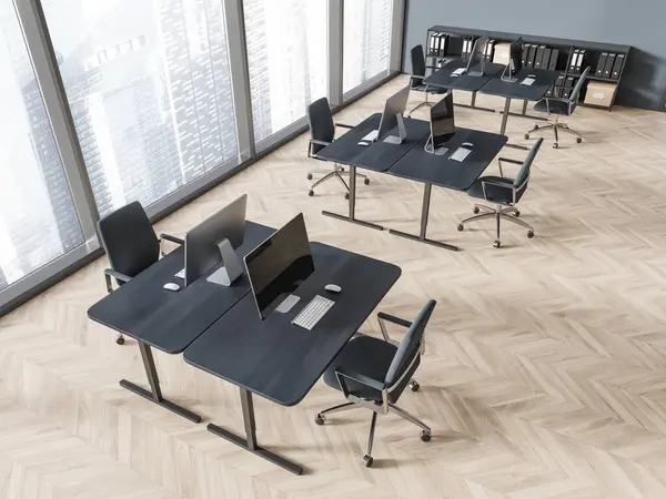 Top view of coworking interior with pc computers on desk, armchairs on hardwood floor. Stylish office workspace with minimalist furniture. Panoramic window on skyscrapers. 3D rendering