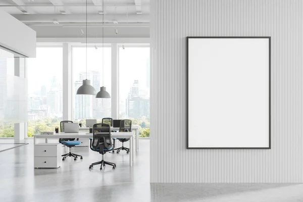 White coworking interior with armchairs, desk with laptop on light concrete floor. Panoramic window on Bangkok skyscrapers. Mock up canvas poster on partition. 3D rendering