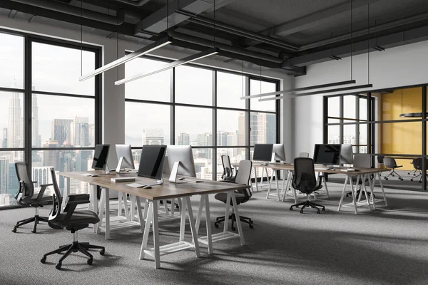 Beyaz ve sarı duvarları olan modern açık uzay ofisinin köşesi, halı döşemesi ve sandalyeli bilgisayar masaları. 3d oluşturma