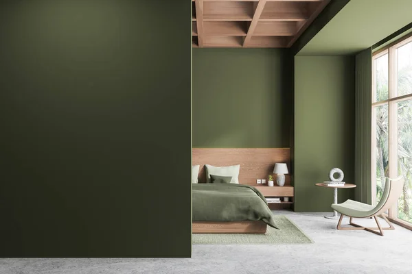 Interior of stylish bedroom with green walls, concrete floor, comfortable king size bed with green cover, cozy armchair and copy space wall on the left. 3d rendering