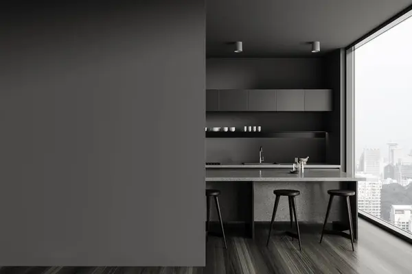 Interior of modern kitchen with gray walls, wooden floor, gray cupboards and cabinets with built in cooker and sink and gray island with stools. Copy space wall on the left. 3d rendering