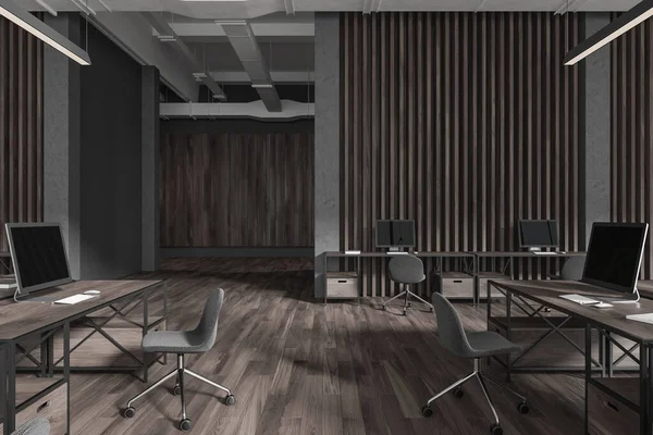 Minimalist dark office interior with pc monitors on desk, coworking space with technology on hardwood floor. Modern workspace in business loft. 3D rendering