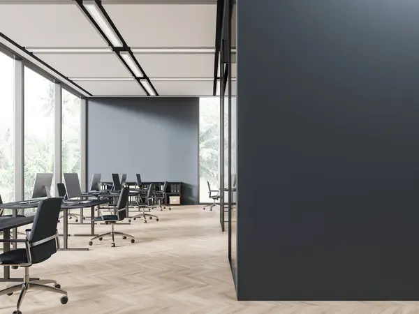 Interior of stylish open space office with gray walls, wooden floor, row of computer desks with gray chairs and copy space wall on the right. 3d rendering