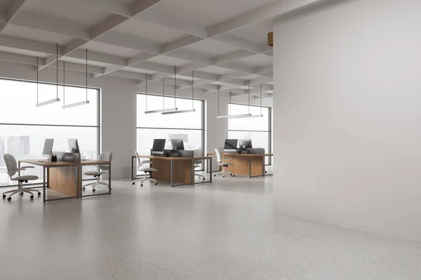 Corner of modern open space office with white walls, concrete floor, row of computer tables with chairs and copy space wall on the right. 3d rendering