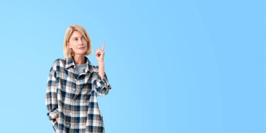 Mavi fotokopi arkaplanının üzerinde duran düşünceli Avrupalı genç bir kadının portresi. Planlama ve beyin fırtınası kavramı