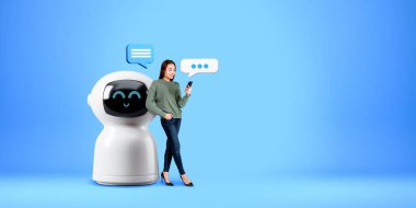 Elinde telefonuyla gülümseyen kadın, çizgi film yapay zeka robotunun yanında dikiliyordu. Fotokopi uzayı boş mavi arka planda konuşma baloncukları vardı. Sanal asistan ve robot iletişimi kavramı