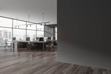 Grey office interior with armchairs and pc computers on desk, side view panoramic window on Kuala Lumpur skyscrapers. Modern coworking corner and mock up empty wall partition. 3D rendering