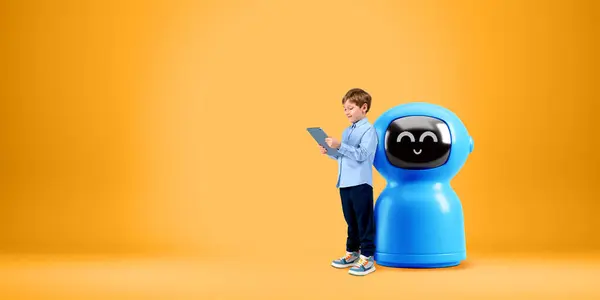 Kid using tablet, standing full length near cartoon AI robot on copy space empty orange background. Concept of chat bot, virtual assistant and machine learning