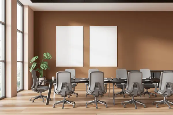 Stylish conference interior with armchairs and table, hardwood floor. Meeting room with panoramic window on skyscrapers. Two mock up square canvas posters on wall. 3D rendering
