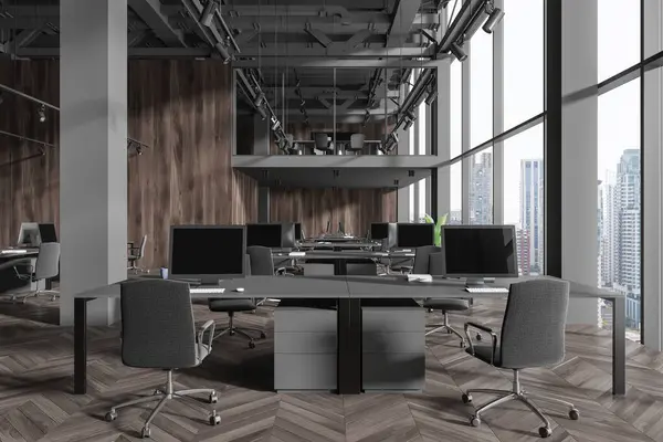 Dark office interior with pc computers and shared desk in row, hardwood floor. Two-storey stylish work space with panoramic window on Bangkok skyscrapers. 3D rendering